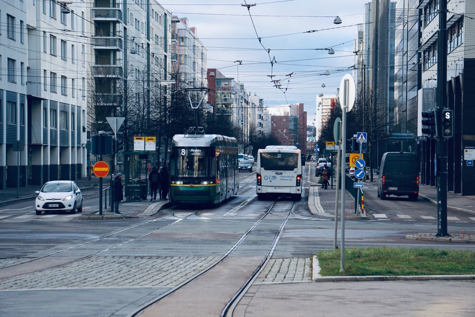 Energia Renovável — A busy Helsinki street featuring a tram and bus with surrounding urban architecture.